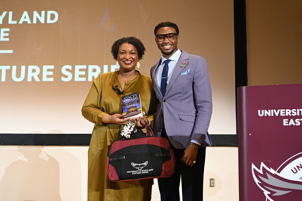 Political candidate stands with student government member.